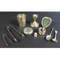 A small group of silver items, comprising a dwarf candlestick, 7 by 7.5cm high, a heart shaped easel... 
