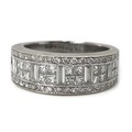 An 18ct white gold and diamond ring, in Art Deco style, circa 1990, with a wide band pave set with a... 