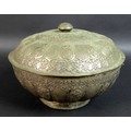 A South East Asian white metal bowl and cover, 19th century, with embossed decoration of scrolling f... 