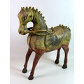A 19th century carved wooden horse, with distressed hand painted colourful decoration, 53 by 18 by 6... 