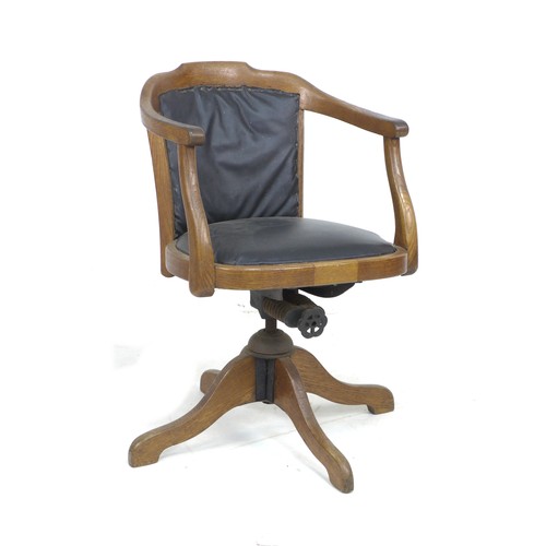 236 - A vintage oak framed office swivel chair, circa 1930, with shaped arms, black leatherette seat and b... 