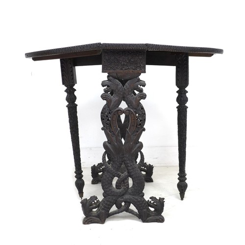 336 - An Anglo-Indian 19th century oval drop leaf table, profusely carved with various animals in scrollin... 