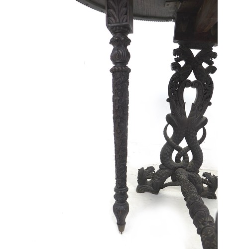 336 - An Anglo-Indian 19th century oval drop leaf table, profusely carved with various animals in scrollin... 