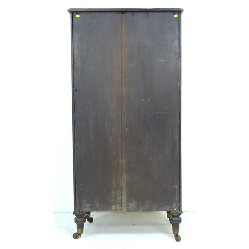 357 - A mid 19th century mahogany cupboard, two double cupboard doors with brass edging, the smaller upper... 