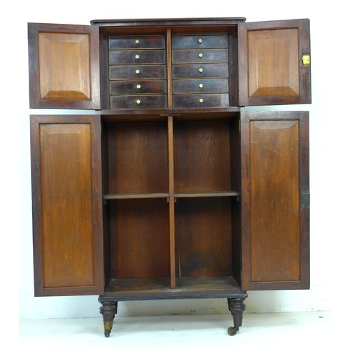 357 - A mid 19th century mahogany cupboard, two double cupboard doors with brass edging, the smaller upper... 