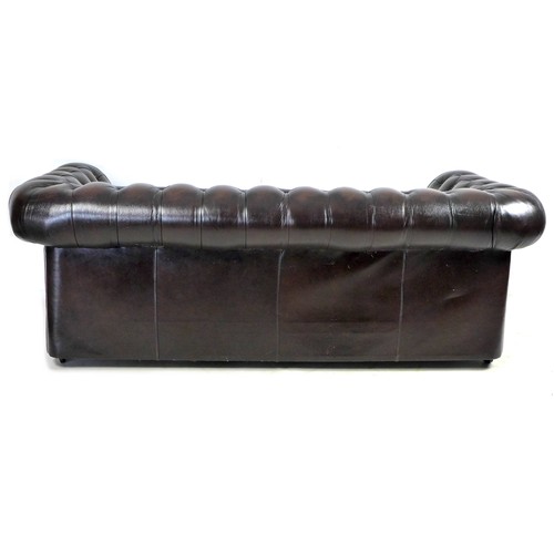 247 - A late 20th century Thomas Lloyd three seater Chesterfield settee in dark brown leather, raised upon... 