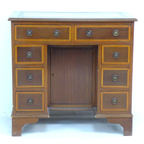 215 - A reproduction kneehole desk, in late Georgian style, eight drawers with ring handles, brown leather... 