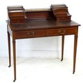 An Edwardian mahogany and line inlaid lady's writing desk, brass gallery and shelf between two conca... 
