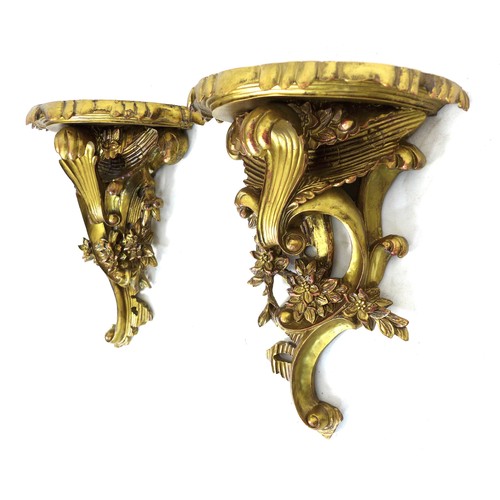 233 - A pair of modern reproduction Rococo style wall brackets, with demi lune surfaces and scroll form bo... 