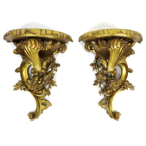 233 - A pair of modern reproduction Rococo style wall brackets, with demi lune surfaces and scroll form bo... 