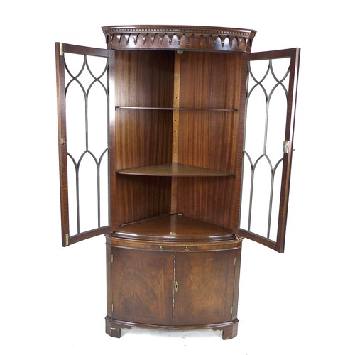 245 - A Reprodux Bevan Funnell mahogany corner cabinet, with astragal glazed double doors, enclosing two s... 