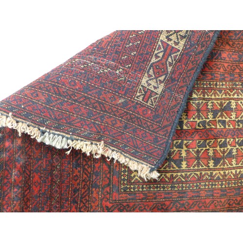 262 - An Old Baluchi rug, with red ground, cream stepped rectangular field, with multiple borders of dark ... 