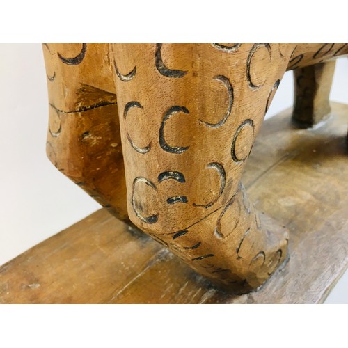 105 - A late 19th century African Asante tribal Leopard stool, with curved seat above a stylised leopard s... 