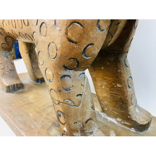 105 - A late 19th century African Asante tribal Leopard stool, with curved seat above a stylised leopard s... 