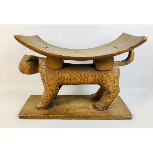 105 - A late 19th century African Asante tribal Leopard stool, with curved seat above a stylised leopard s... 