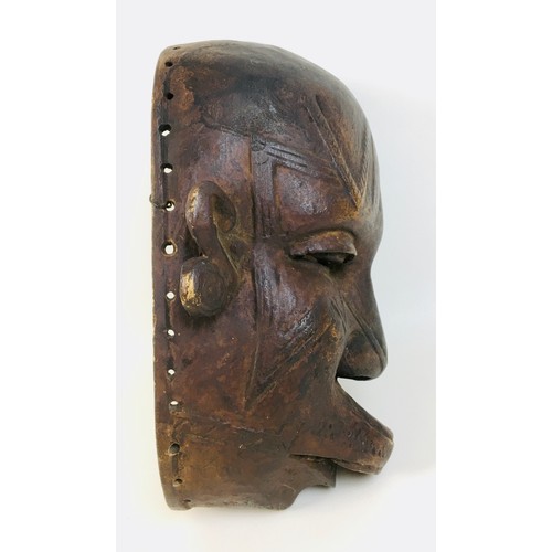 102 - An African Makondo tribal carved wooden mask, depicting a female face with facial scarations, a lip ... 