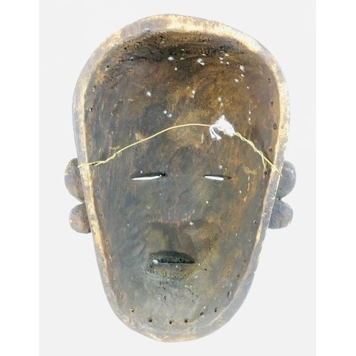 102 - An African Makondo tribal carved wooden mask, depicting a female face with facial scarations, a lip ... 