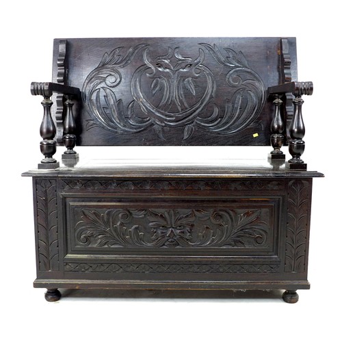 306 - A stained and carved oak monk's bench, mid 20th century, with lifting and sliding top, a/f detached ... 