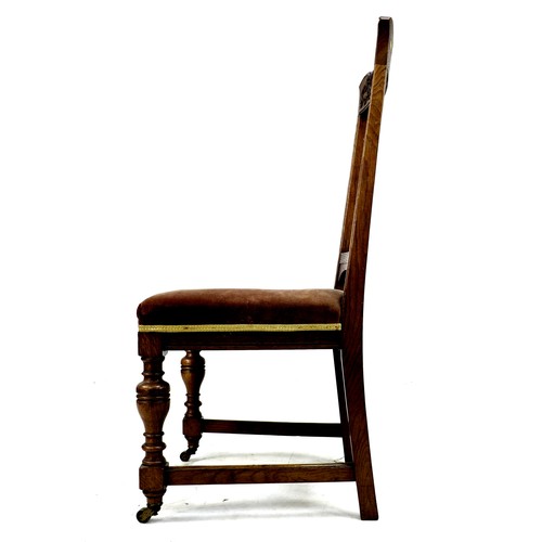 307 - A set of four late Victorian oak dining chairs, the rails carved with fruit and ribbons, slat backs,... 