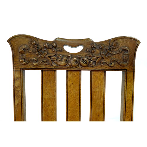 307 - A set of four late Victorian oak dining chairs, the rails carved with fruit and ribbons, slat backs,... 