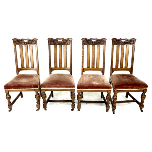 307 - A set of four late Victorian oak dining chairs, the rails carved with fruit and ribbons, slat backs,... 