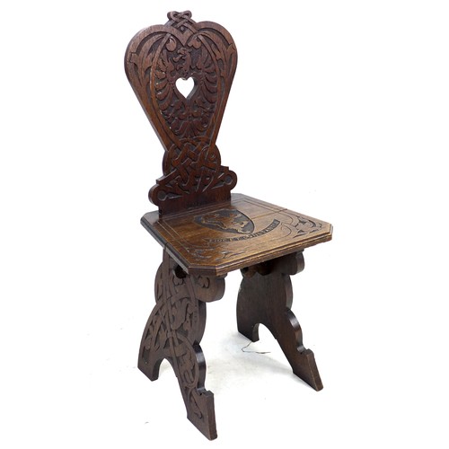 292 - A mid 20th century stained oak hall chair, the seat and back carved with a lion crest and motto 'Fid... 