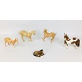 A group of five Beswick horse figurines, comprising three palomino horses, one standing with repaire... 
