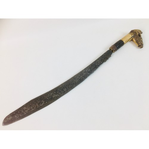 133 - A Dayak mandau sword Borneo, Indonesia, the curved steel blade with engraved decoration to each side... 