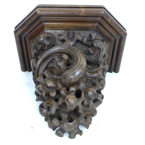 115 - A carved wooden wall bracket, early 20th century, carved in high relief with foliate scrolling decor... 