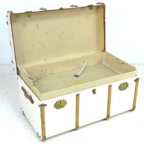 203 - An early 20th century travelling trunk, white painted canvas and wooden bound, leather carrying hand... 