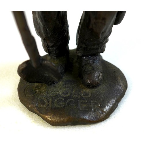 95 - A bronze sculpture of a miner, the man dressed in working clothes carrying a pickaxe in one hand and... 