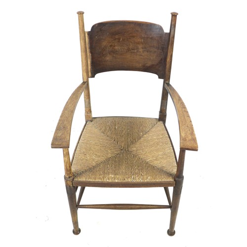 264 - An Arts and Crafts oak open arm nursing chair, of Glasgow School influence, with rush seat and curve... 