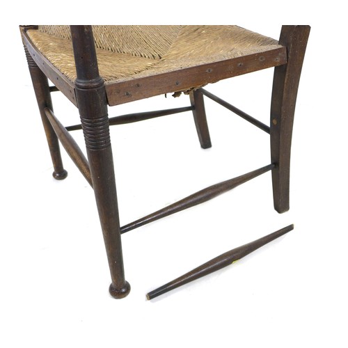 264 - An Arts and Crafts oak open arm nursing chair, of Glasgow School influence, with rush seat and curve... 