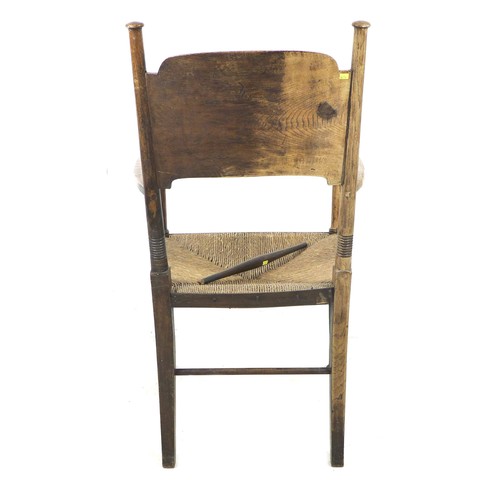 264 - An Arts and Crafts oak open arm nursing chair, of Glasgow School influence, with rush seat and curve... 