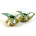 A pair of Dutch Art Deco jugs of squat curvilinear design with slip glaze in pale green, buff and br... 