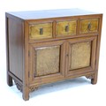 A Chinese hardwood cabinet, early to mid 20th century, with three frieze drawers with veneered front... 