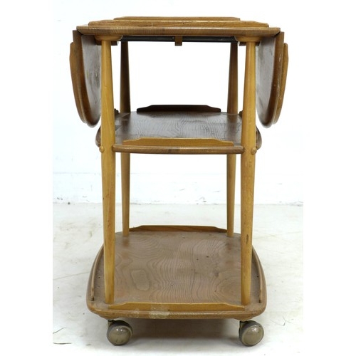 275 - An Ercol elm and beech tea trolley, circa 1970, with drop leaves and three tiers, ball castors, mode... 