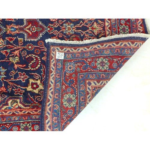 305 - A hand knotted wool Hamadan rug, with central red medallion upon a blue ground and red ground border... 