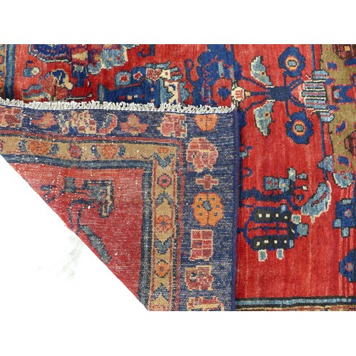 223 - A hand knotted wool Hamadan rug, with zoomorphic designs upon a red ground and with causcasian and b... 