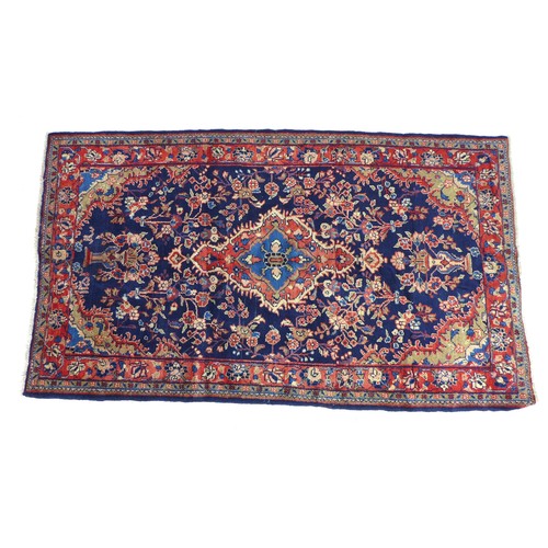 294 - A hand knotted wool Hamadan rug, with central medallion flanked by floral sprays upon a blue ground,... 