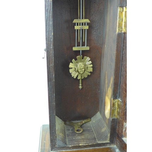 283 - A 19th century mahogany wall clock, with narrow case, and brass crest to domed top, with pendulum an... 