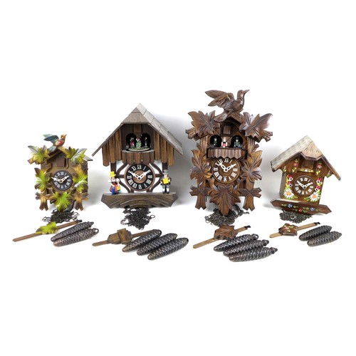 151 - A group of four modern wooden cuckoo clocks, each with pendulum and weights, largest case 23 by 18 b... 