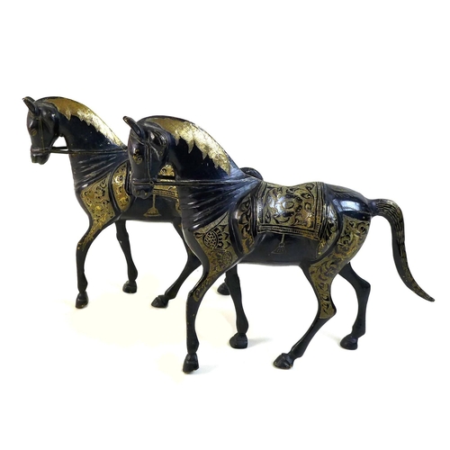11 - A pair of lacquered brass horses, likely 19th century Indian or Chinese, the etched back design deta... 