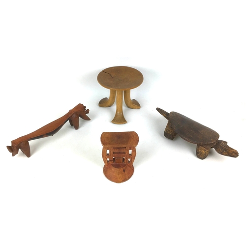 150 - A group of four tribal carved wooden items, comprising a small Ethiopian tripod stool, with circular... 