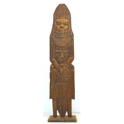 151 - A mid 20th century tribal, Benin style carved wooden figure, wearing full armour and holding a sword... 