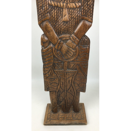 151 - A mid 20th century tribal, Benin style carved wooden figure, wearing full armour and holding a sword... 