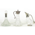 A group of three glass decanters, comprising a ship's decanter with silver plated 'Green Man' mask s... 