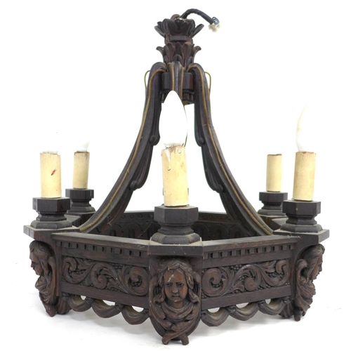 284 - A mid 20th century carved oak chandelier, of hexagonal form with swept supporting arms, carved with ... 