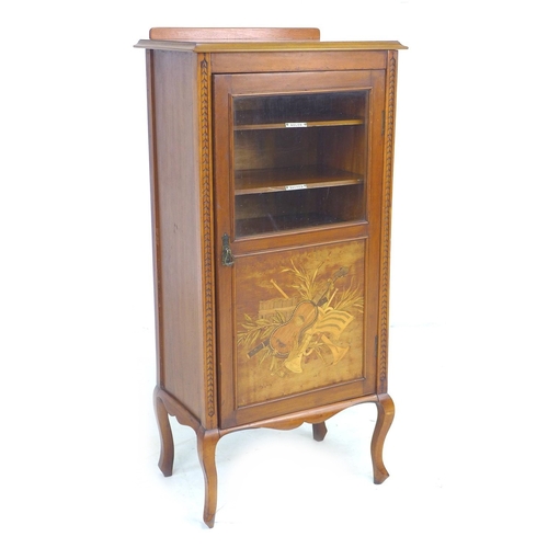 303 - An Edwardian mahogany music cabinet with later top, the door with glass above a marquetry panel depi... 