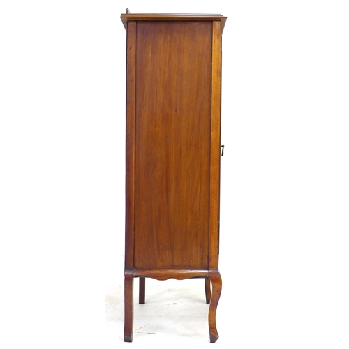 303 - An Edwardian mahogany music cabinet with later top, the door with glass above a marquetry panel depi... 